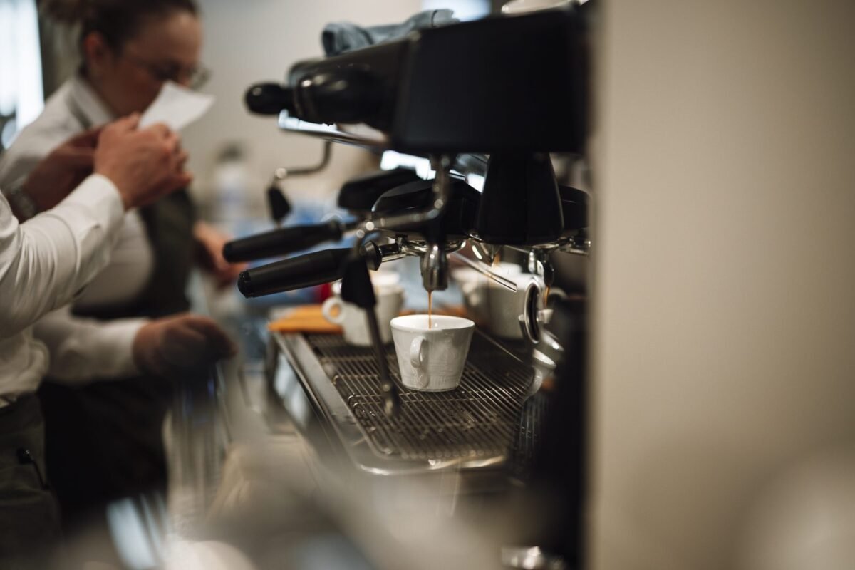 A barista preparing coffee at a busy café counter