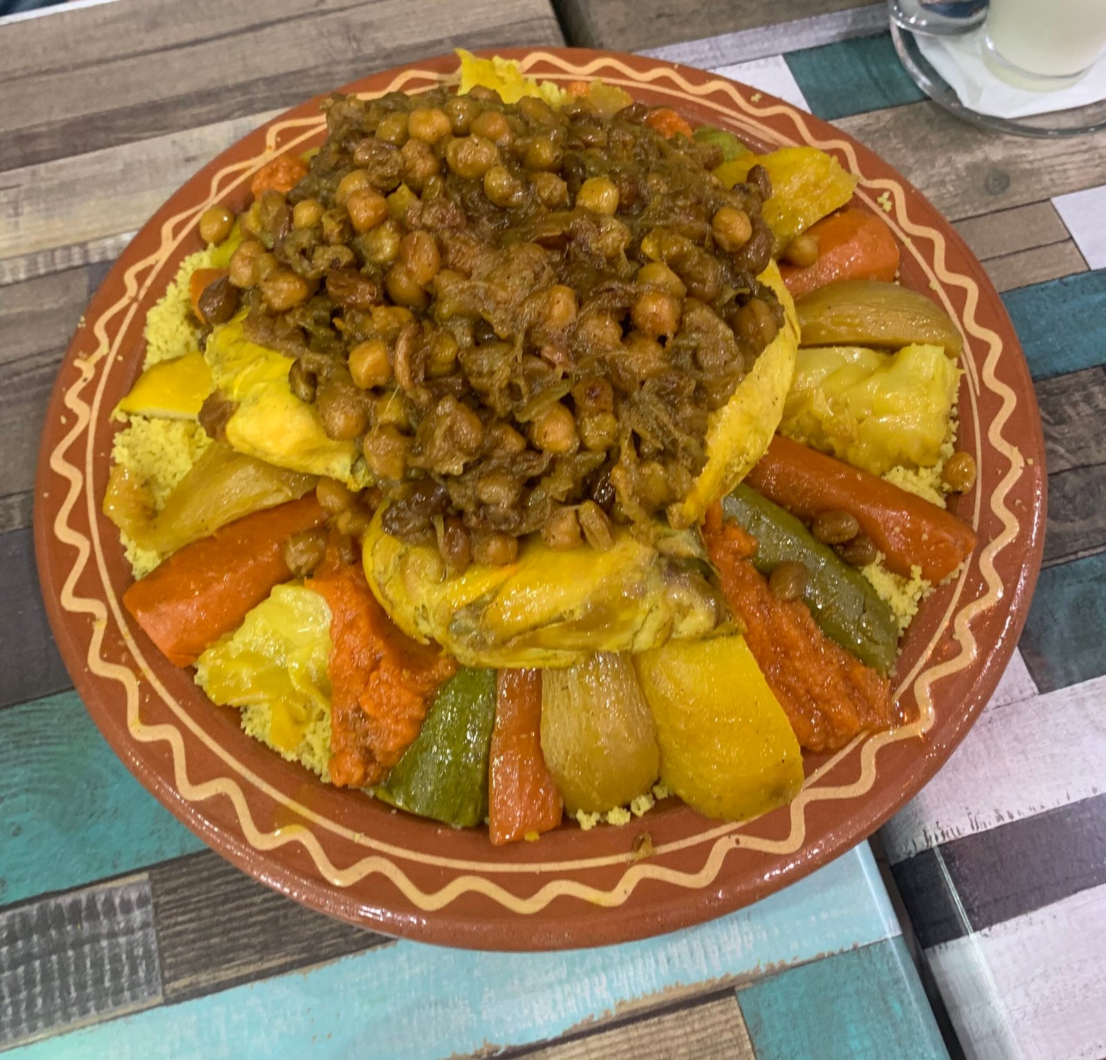 Moroccan couscous platter with seven vegetables and caramelized onion and chickpea topping