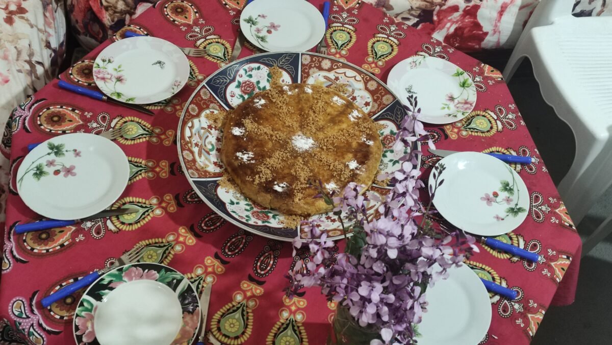 A whole pigeon pastilla dusted with powdered sugar and cinnamon on a decorated platter