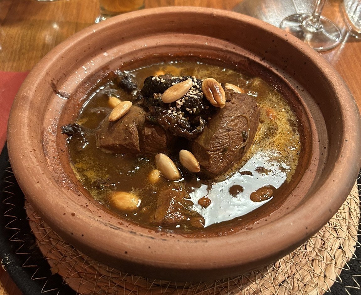 Tajine d'agneau aux pruneaux et aux amandes dans un plat en terre