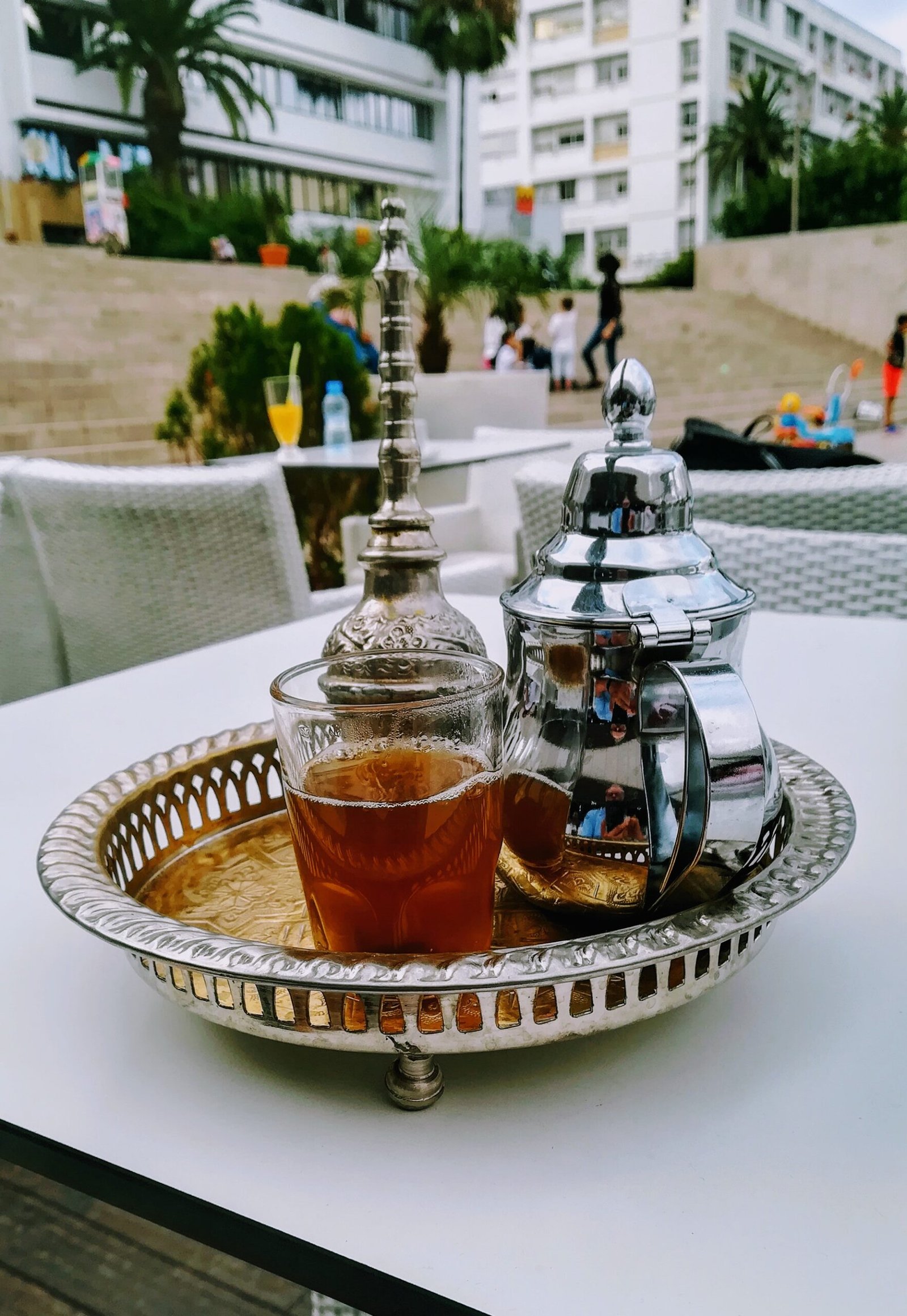 Moroccan mint tea poured from height into glasses on a traditional tray