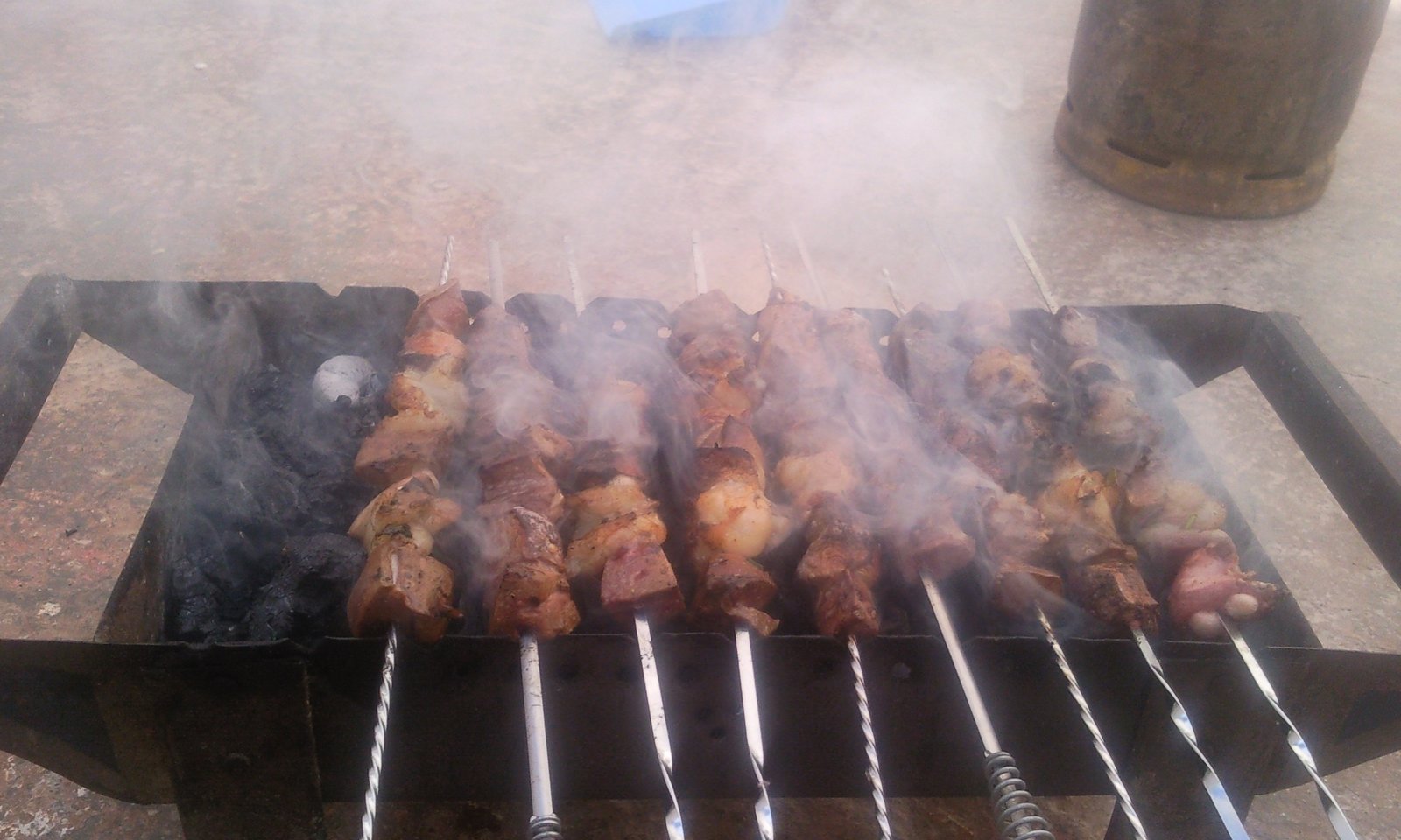 Charcoal grill with skewers and sausages at a Moroccan street food stall