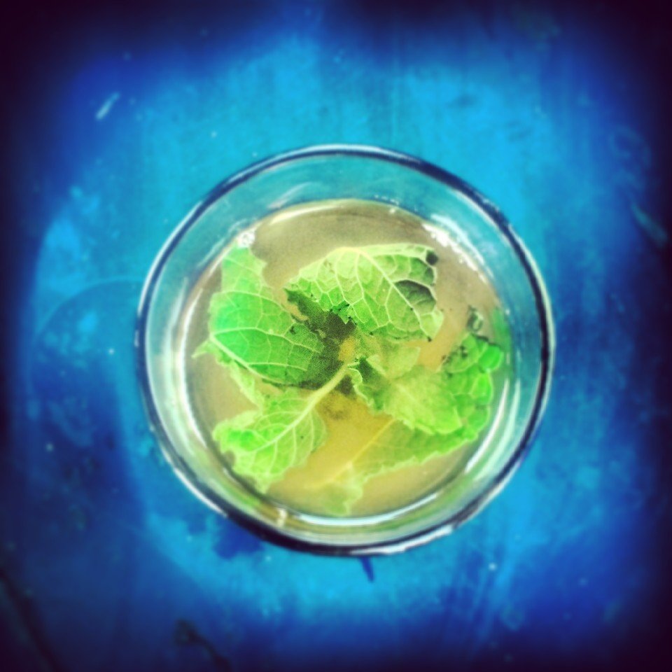 Glasses of Moroccan mint tea poured from a teapot, the classic pairing with hot sfenj