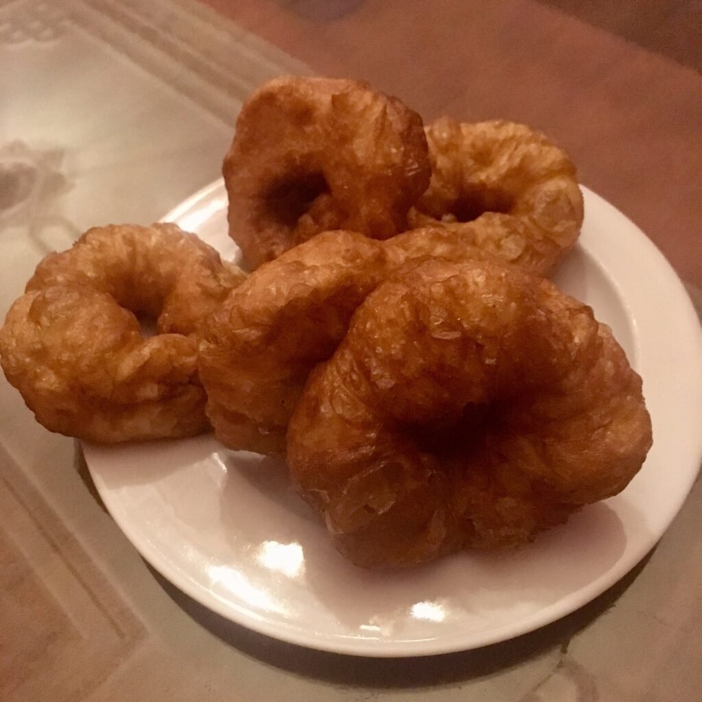 Sfenj rings being deep-fried in a traditional wide pan in Marrakesh, Morocco