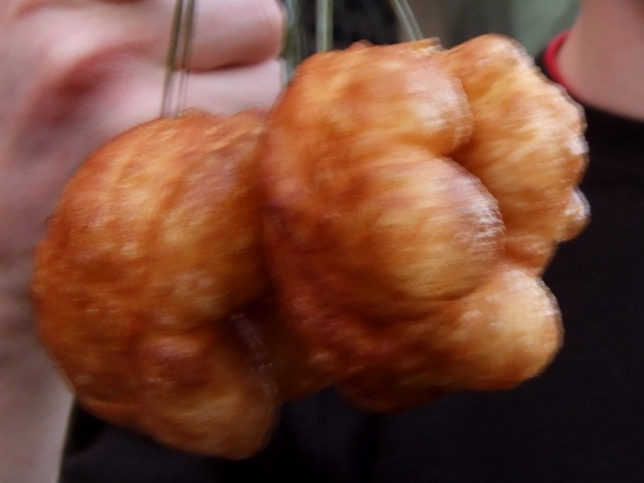 Close-up of golden sfenj rings showing the crisp crust and spongy texture
