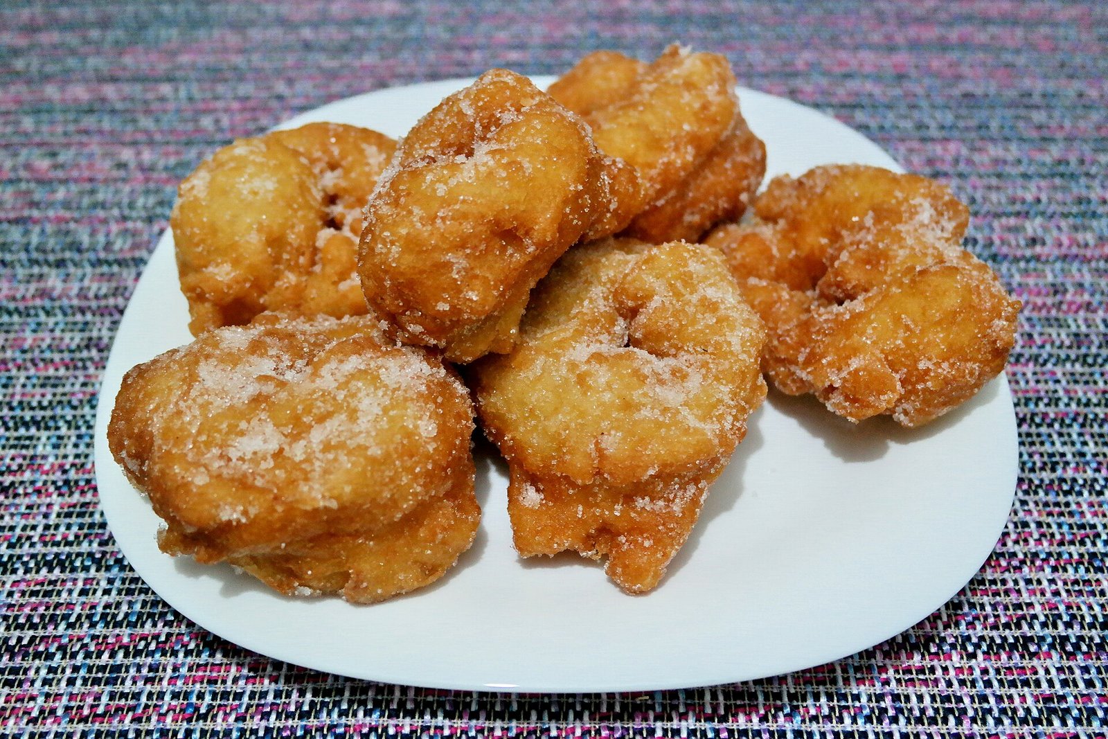 Sfenj dusted with sugar served on a plate