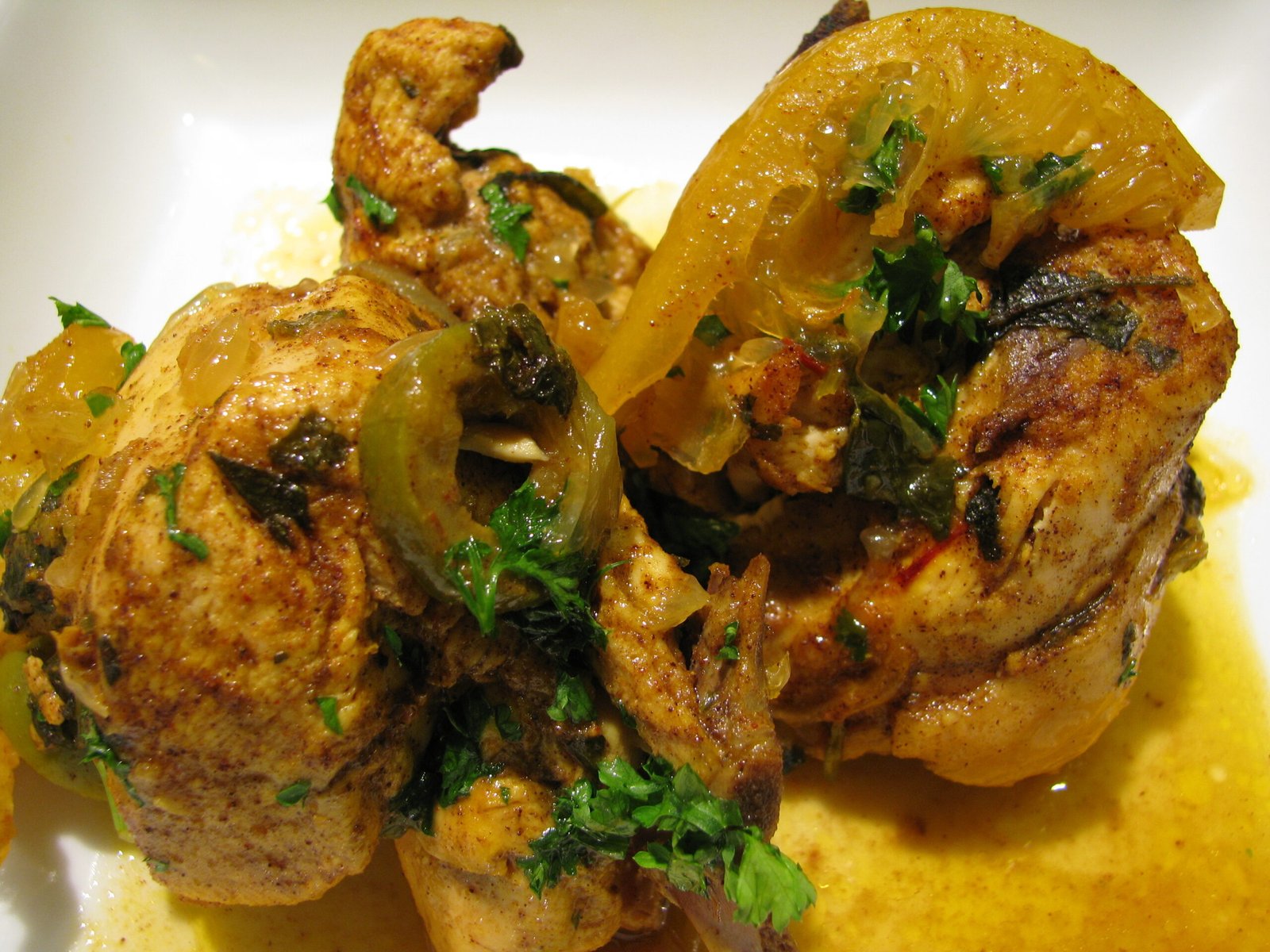 Chicken tagine with preserved lemons and green olives in a traditional clay tagine