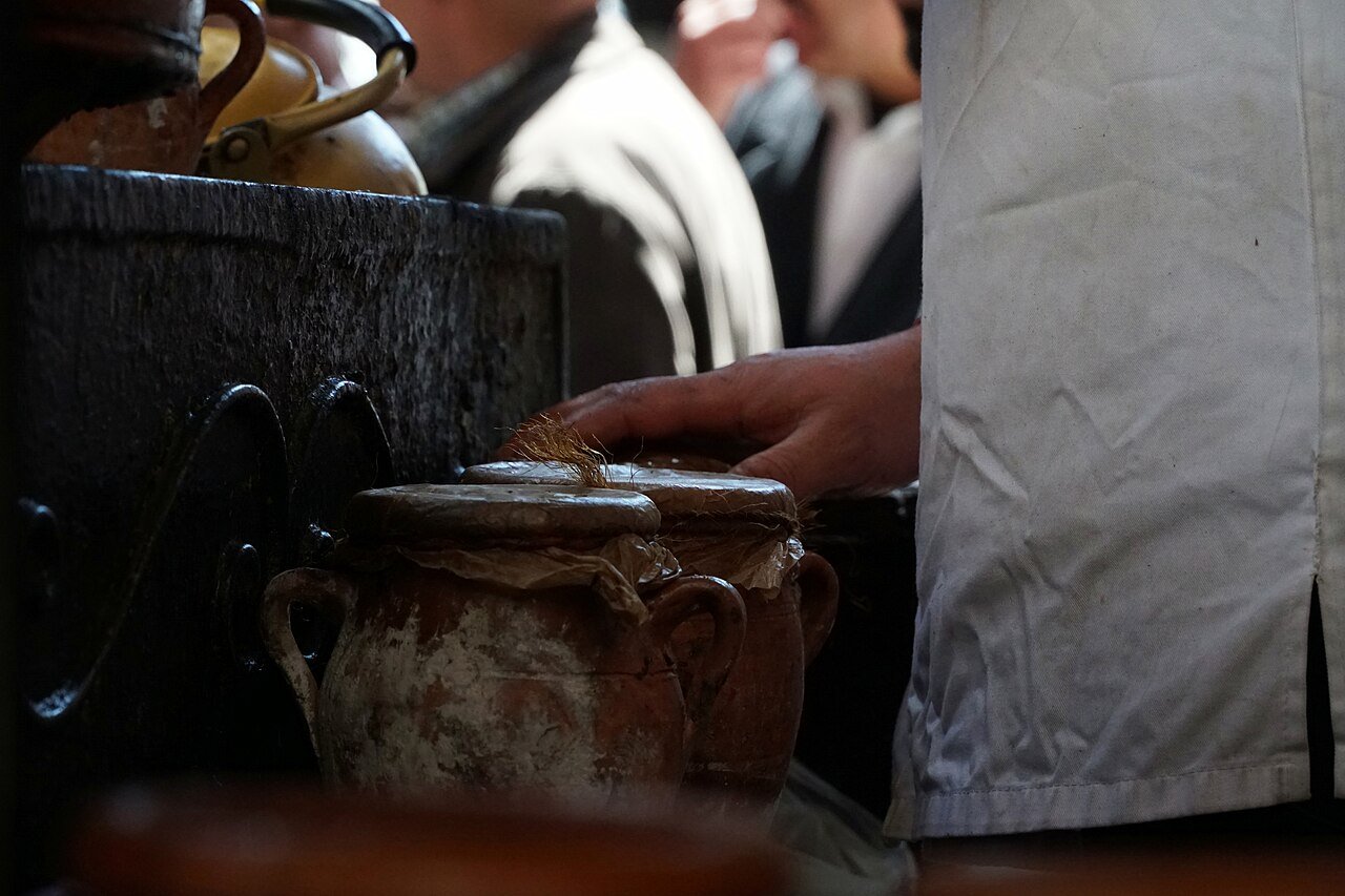 Urnes d'argile de tanjia scellées alignées devant un four à Marrakech, attachées avec papier et ficelle